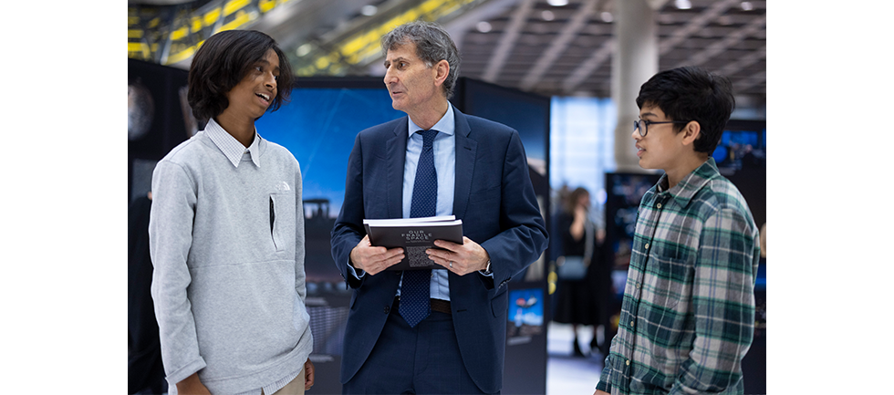 Image of our competition winners speaking with Max Alexander, exhibition artist
